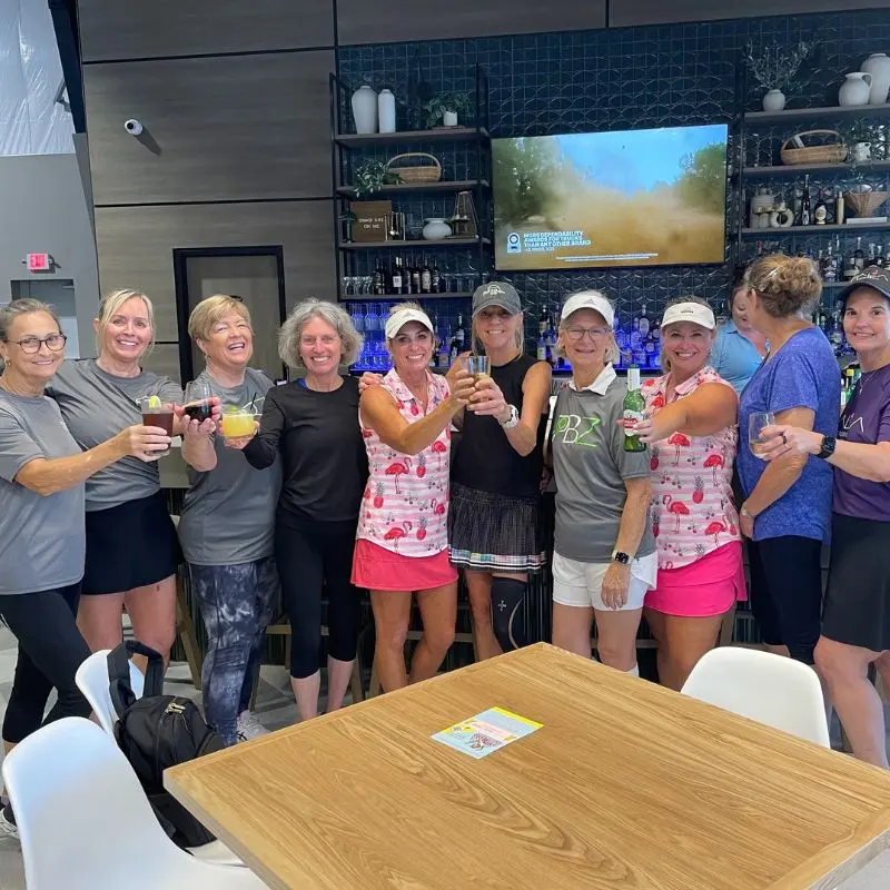 Friends raising drinks at the bar after a game