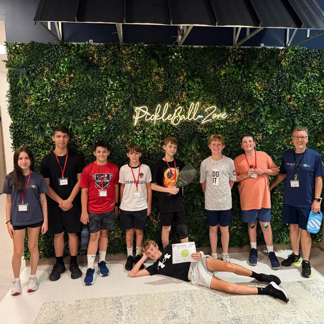 Junior players goofing around under the neon sign