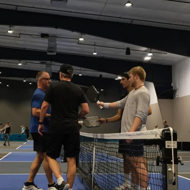Players shaking hands at the net after a game