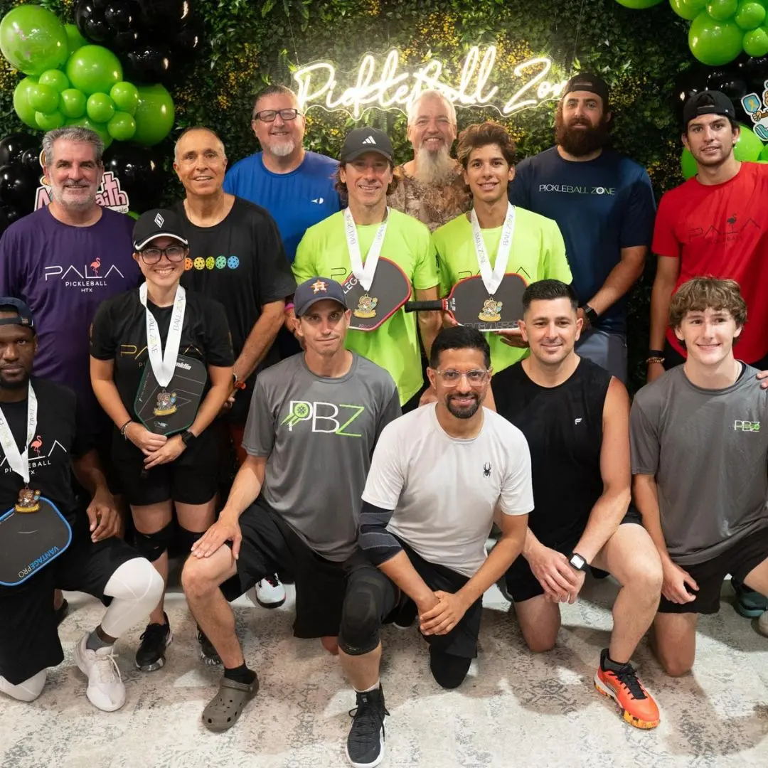 Tournament medal winners posing in front of balloons